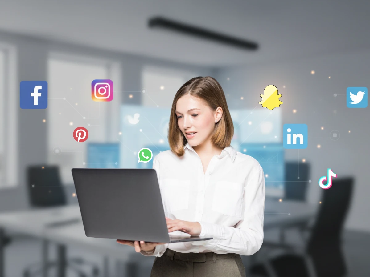 Young woman using a laptop with floating social media icons.